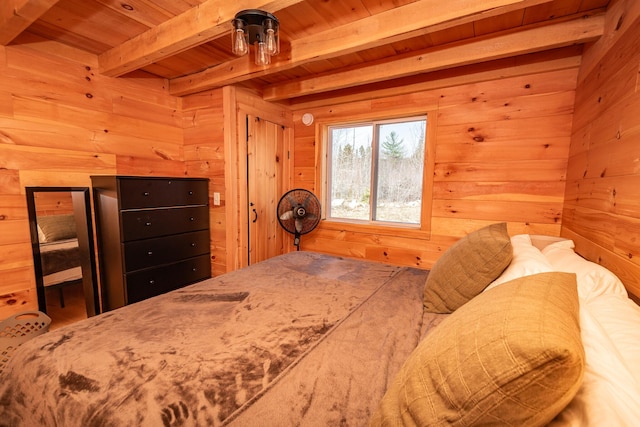 bedroom with beam ceiling, wood walls, and wood ceiling