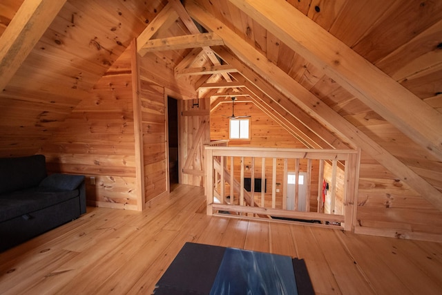 additional living space featuring wood ceiling, lofted ceiling with beams, wood walls, and hardwood / wood-style floors