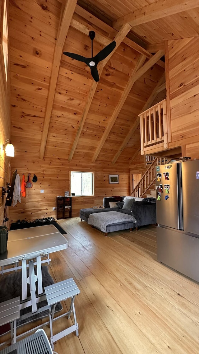 bedroom with wood ceiling, hardwood / wood-style flooring, freestanding refrigerator, and wood walls