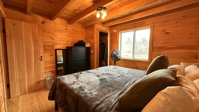 bedroom featuring beamed ceiling, wood walls, wood ceiling, and light wood finished floors