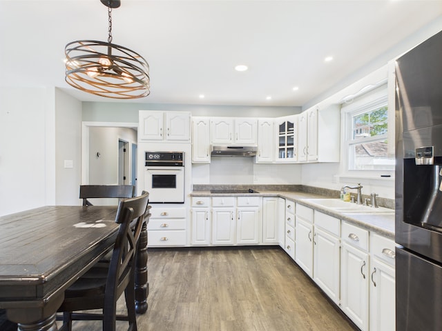 80 Garden Cir, Caribou, ME 04736 - kitchen featuring oven, stainless steel fridge with ice dispenser, a sink, under cabinet range hood, and white cabinetry