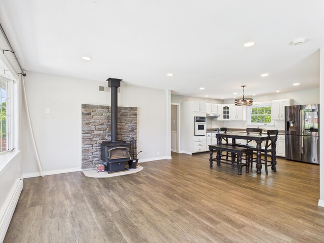 80 Garden Cir, Caribou, ME 04736 - dining area featuring a wood stove, dark wood-style flooring, recessed lighting, baseboard heating, and baseboards