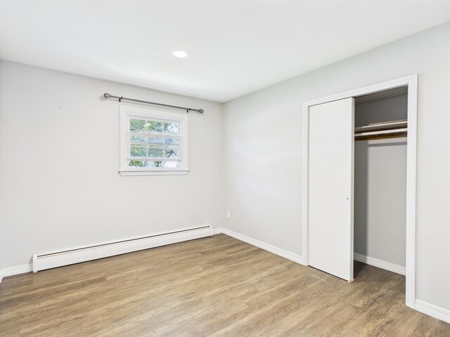 80 Garden Cir, Caribou, ME 04736 - unfurnished bedroom featuring baseboard heating, wood finished floors, a closet, and baseboards