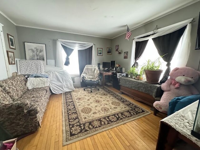 living area with ornamental molding and hardwood / wood-style floors