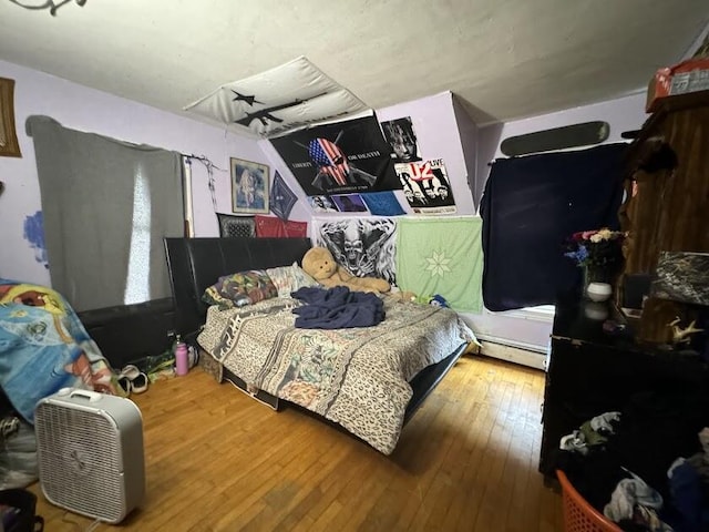 bedroom featuring wood-type flooring and baseboard heating