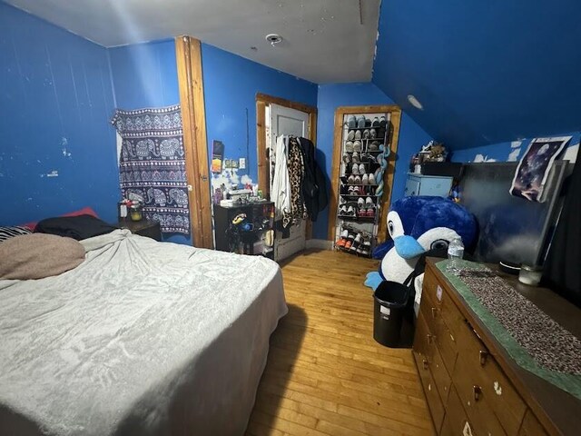 bedroom featuring wood-type flooring and vaulted ceiling