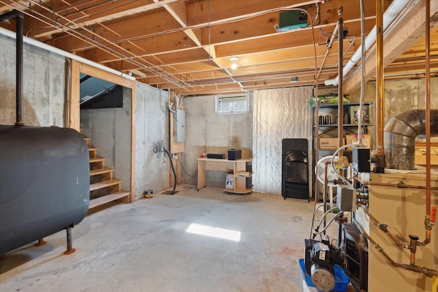 below grade area featuring heating fuel, stairway, and electric panel