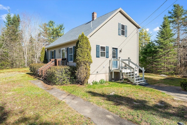 view of property exterior with a shingled roof, a yard, and a chimney