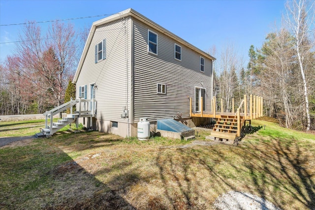 rear view of property with a wooden deck and a yard