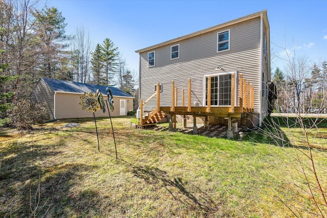 rear view of property featuring a lawn, stairs, an outbuilding, and a deck