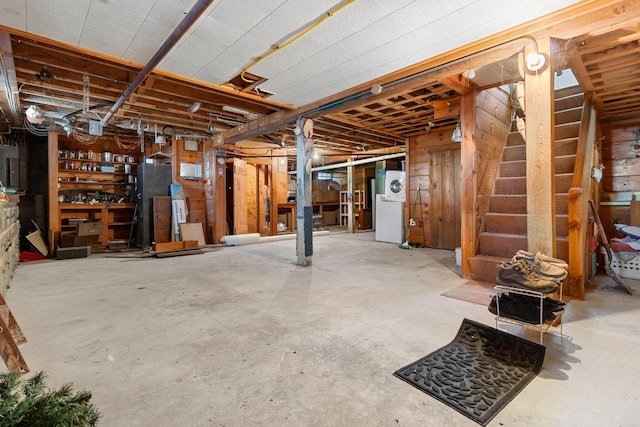 unfinished below grade area featuring electric panel and washer / clothes dryer
