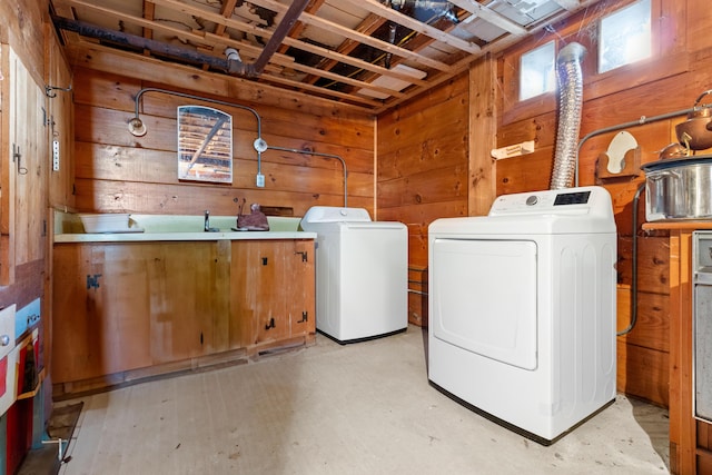 laundry room with laundry area, wood walls, and washing machine and clothes dryer