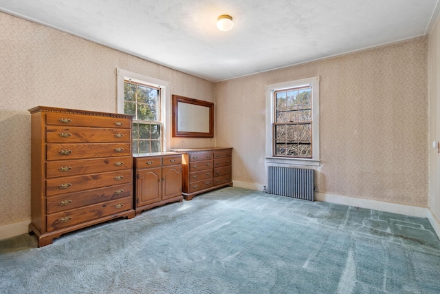 empty room with radiator heating unit, plenty of natural light, and wallpapered walls