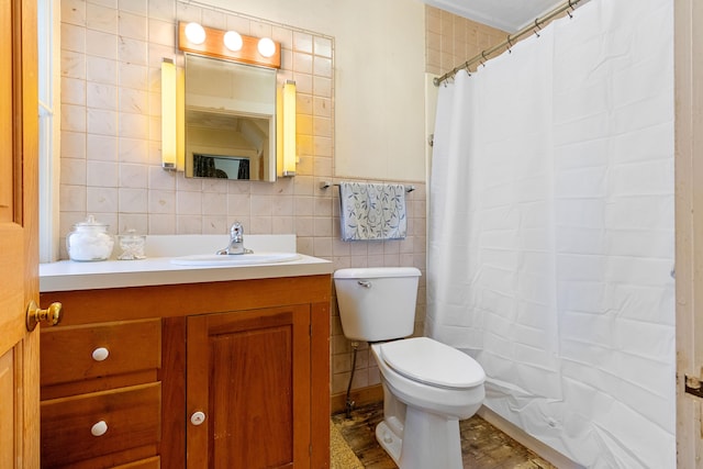 bathroom with toilet, a shower with curtain, tile walls, and vanity
