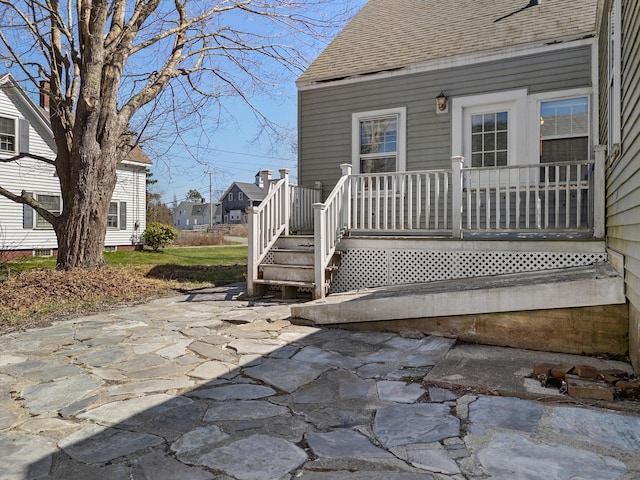 exterior space featuring a patio and roof with shingles