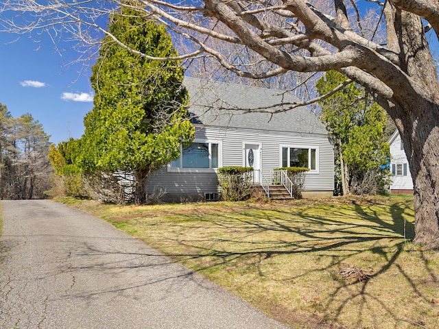 view of front facade with a shingled roof and a front yard