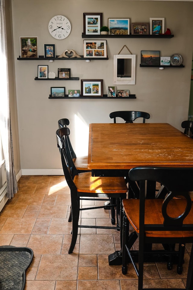 dining room with baseboards and stone tile flooring