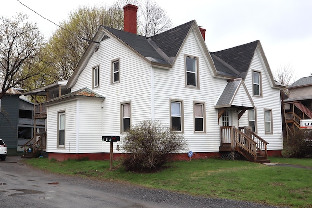 12 Sherwin St, Waterville, ME 04901 - view of home's exterior with roof with shingles, a yard, and a chimney