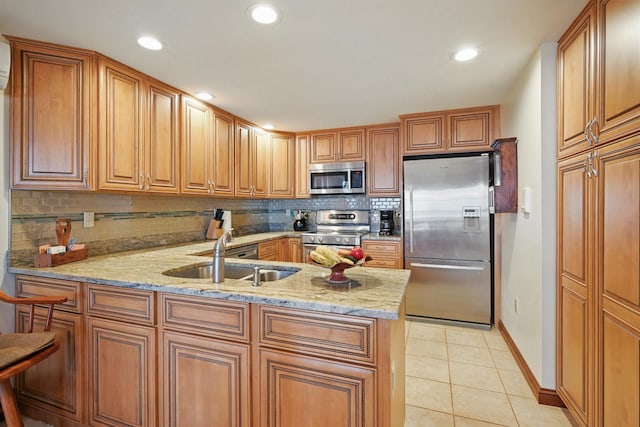 39 Turtle Run Rd Unit 8, Winthrop, ME 04364 - kitchen with a peninsula, light tile patterned floors, a sink, appliances with stainless steel finishes, and decorative backsplash