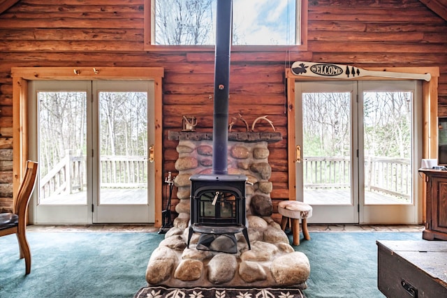 26 Mountain View Ln, Woodstock, ME 04219 - carpeted living area featuring a wood stove, plenty of natural light, and rustic walls