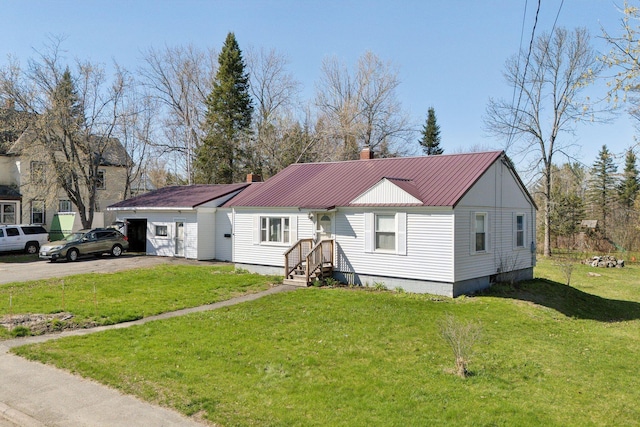 232 Peltoma Ave, Pittsfield, ME 04967 - view of front of house with a chimney, a front yard, metal roof, and asphalt driveway