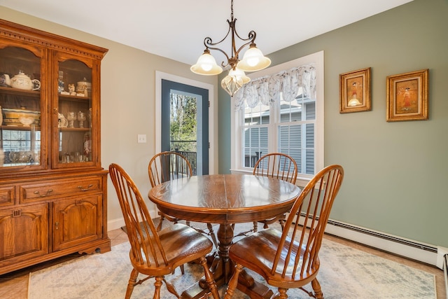 dining room featuring a chandelier, a baseboard radiator, and baseboards
