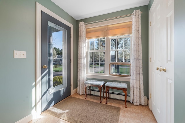 doorway featuring tile patterned floors, baseboards, baseboard heating, and a healthy amount of sunlight