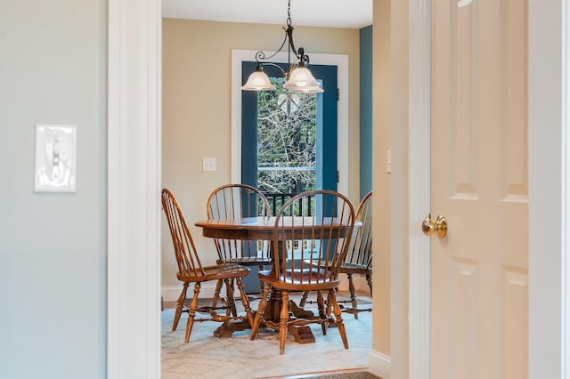 carpeted dining space featuring baseboards