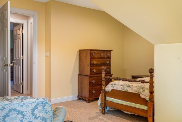 bedroom featuring light colored carpet and lofted ceiling