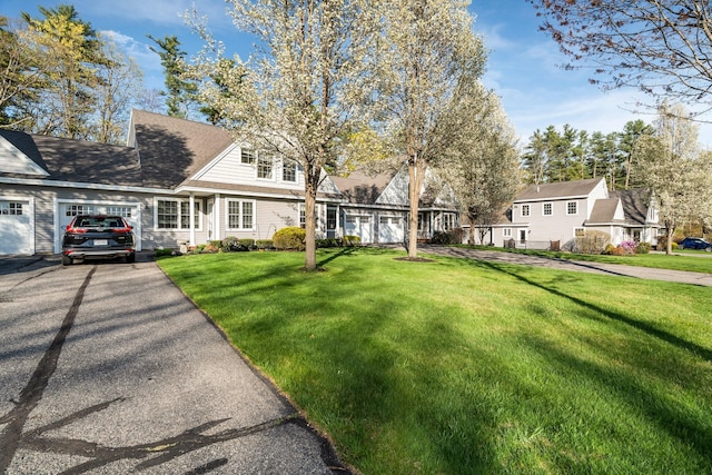 view of front facade featuring a front lawn, driveway, and an attached garage