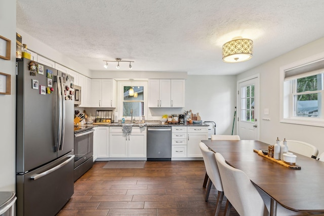 178 Bradley St, Saco, ME 04072 - kitchen featuring appliances with stainless steel finishes, white cabinets, dark countertops, a sink, and dark wood-type flooring