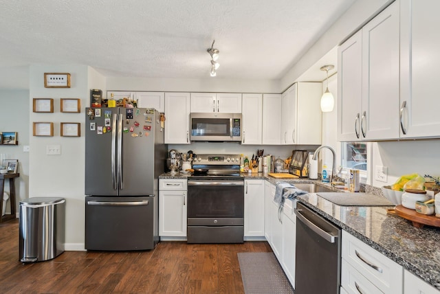 178 Bradley St, Saco, ME 04072 - kitchen featuring stainless steel appliances, dark wood-style floors, white cabinetry, dark stone counters, and a sink