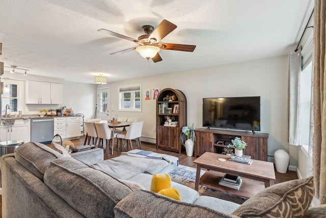 178 Bradley St, Saco, ME 04072 - living area with a ceiling fan, dark wood-style flooring, a baseboard heating unit, baseboards, and a textured ceiling