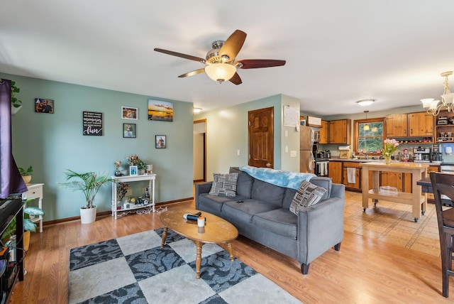 178 Bradley St, Saco, ME 04072 - living room with a ceiling fan, a chandelier, light wood finished floors, and baseboards