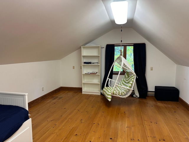 bonus room with light wood-type flooring, lofted ceiling, baseboards, and a baseboard radiator