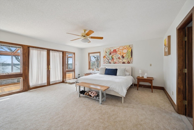 bedroom featuring access to exterior, multiple windows, a textured ceiling, light colored carpet, and ceiling fan