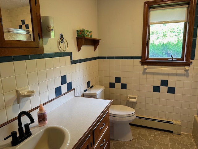 bathroom featuring baseboard heating, tile walls, toilet, tile patterned flooring, and a wainscoted wall