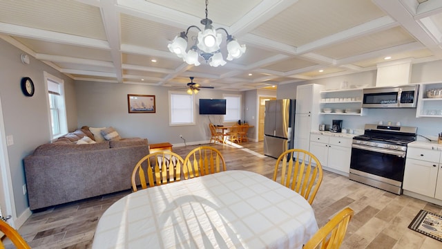 dining room featuring plenty of natural light, ceiling fan with notable chandelier, and light wood-type flooring