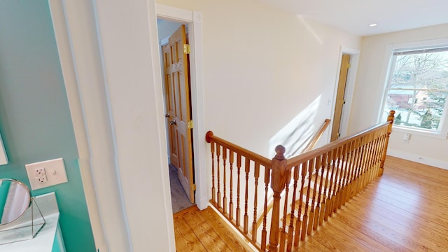 stairway featuring baseboards and hardwood / wood-style flooring