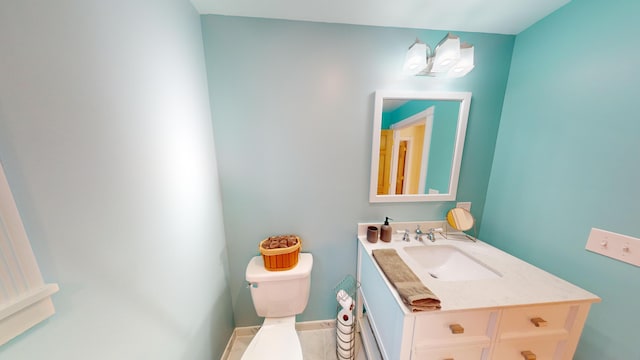 bathroom with vanity, baseboards, and toilet