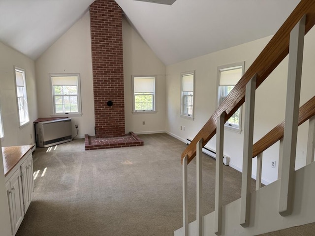 unfurnished living room with plenty of natural light, carpet, and stairway