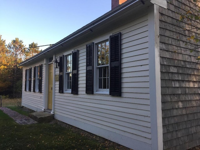 view of property exterior with a chimney and entry steps