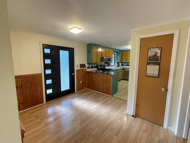 45 Seaview Ter, Belfast, ME 04915 - kitchen featuring appliances with stainless steel finishes, a peninsula, light wood-type flooring, crown molding, and brown cabinetry