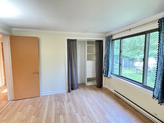 45 Seaview Ter, Belfast, ME 04915 - unfurnished bedroom featuring a baseboard radiator, ornamental molding, light wood-style floors, and a closet