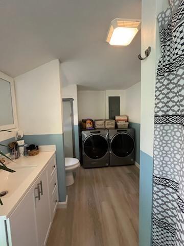 924 Great Pond Rd, Great Pond, ME 04408 - full bathroom with separate washer and dryer, wood finished floors, curtained shower, toilet, and vanity