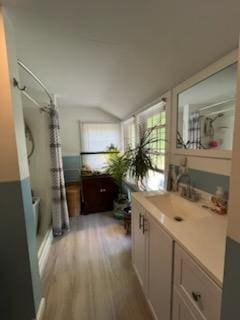 924 Great Pond Rd, Great Pond, ME 04408 - bathroom with wood finished floors, vaulted ceiling, plenty of natural light, vanity, and shower / bath combo with shower curtain