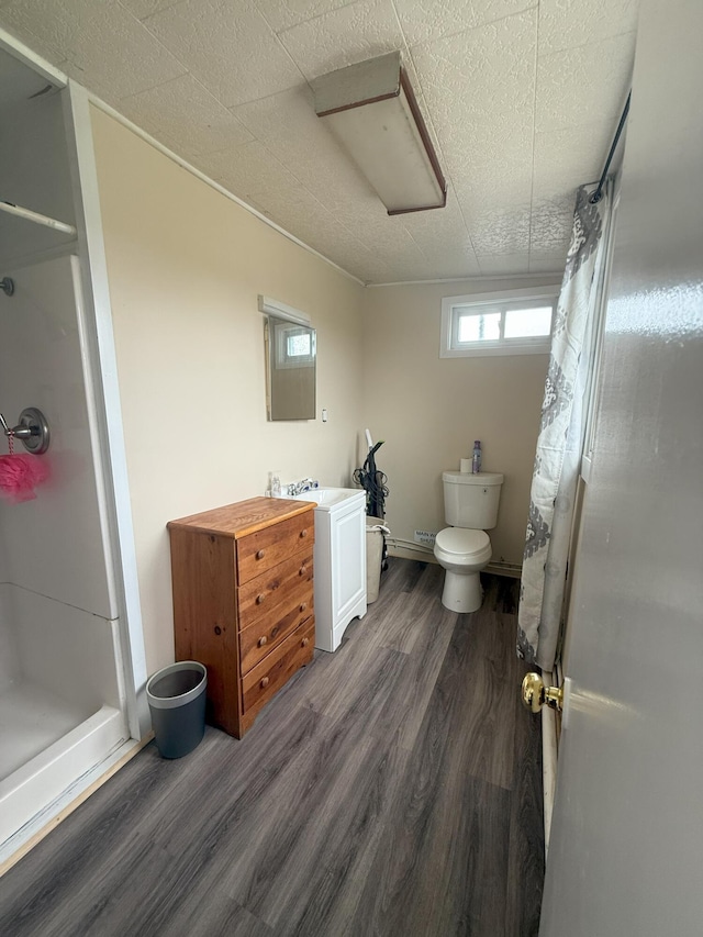 bathroom featuring a shower with curtain, wood finished floors, and toilet