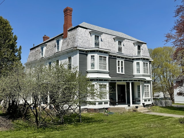 17 Boynton St, Eastport, ME 04631 - rear view of house with a chimney, a yard, and covered porch