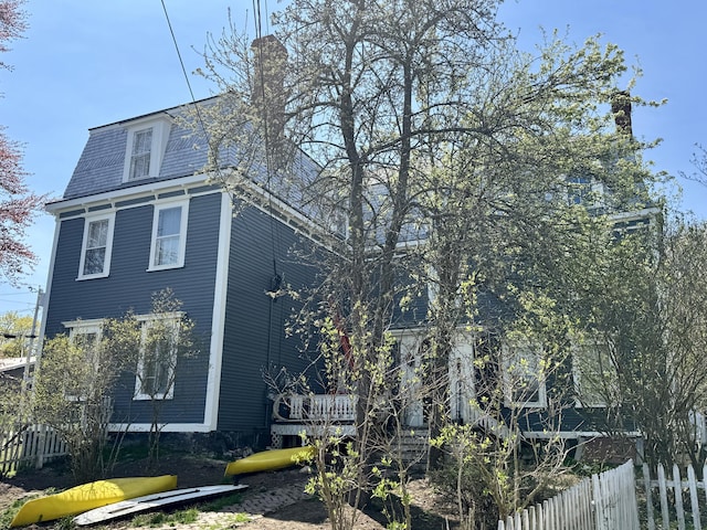 17 Boynton St, Eastport, ME 04631 - view of side of home featuring a chimney, a wooden deck, and mansard roof