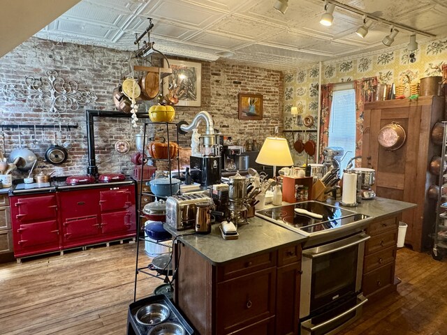 17 Boynton St, Eastport, ME 04631 - kitchen featuring hardwood / wood-style flooring, brick wall, an ornate ceiling, stainless steel range with electric stovetop, and rail lighting